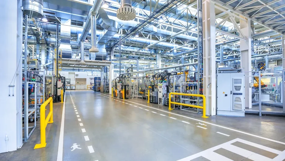 Corredor de fábrica com equipamentos e sinalização no piso